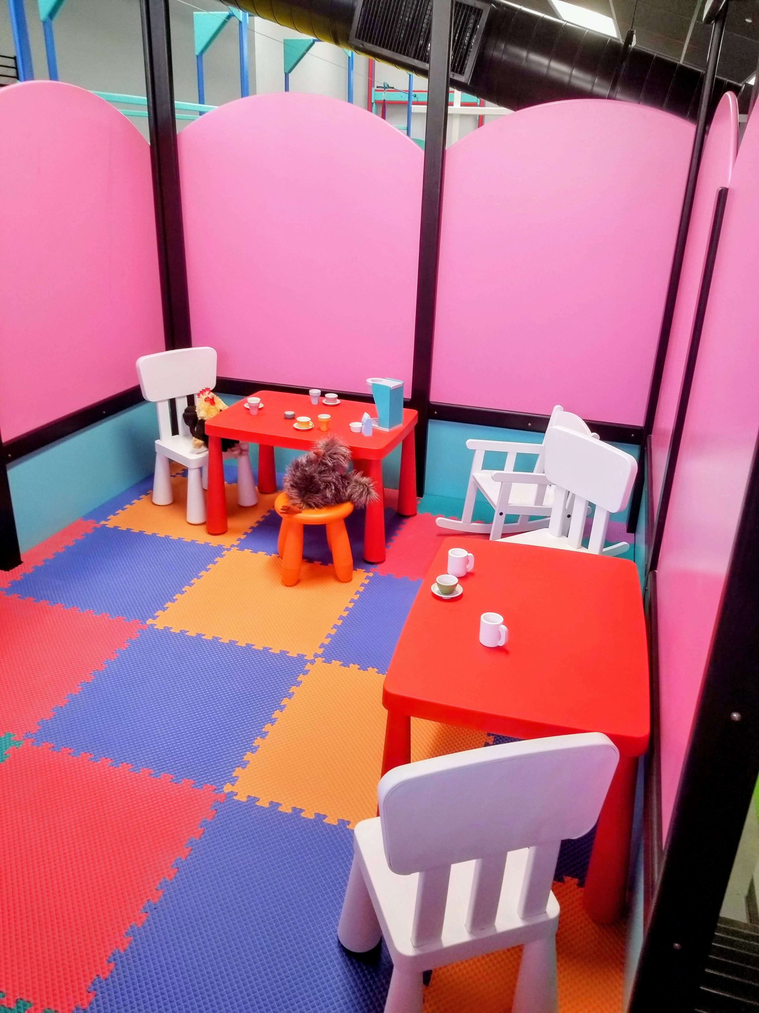 Custom calming zone with pink padded walls and child-sized tea party area