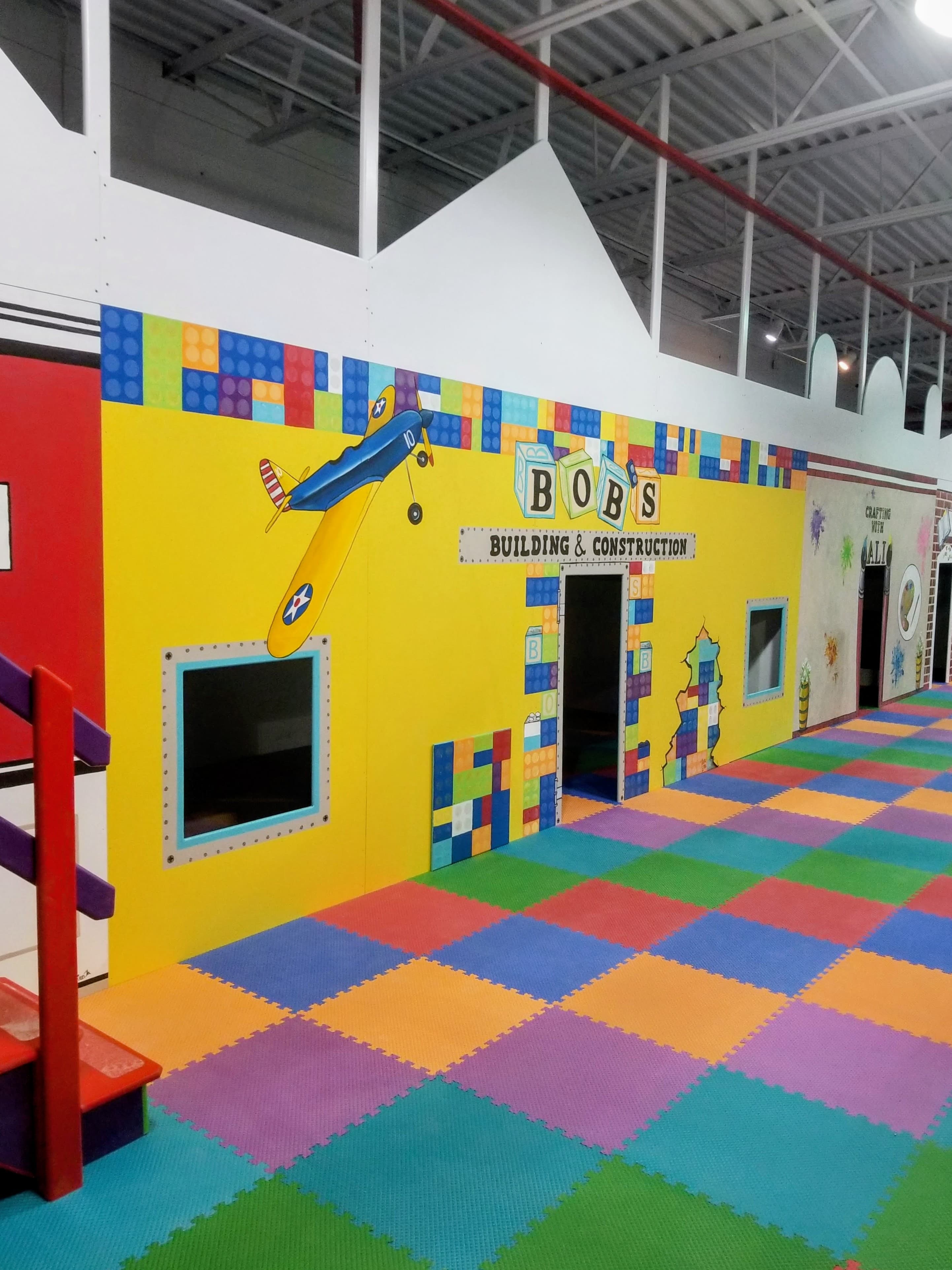 Daycare sensory gym with green slide and saucer swing